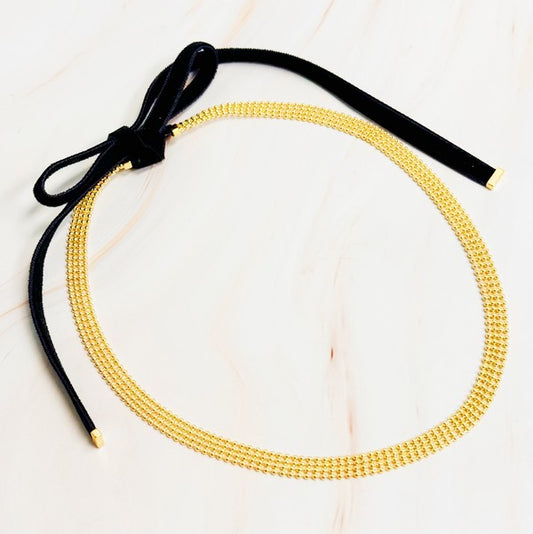 Elevate your style with the Tied in Gold Choker-Style Necklace by Ellison and Young. Featuring a delicate gold chain complemented by a chic black velvety ribbon tie, this versatile accessory adds a touch of elegance to any outfit. Perfect for day-to-night transitions, it effortlessly blends timeless sophistication with modern flair.
